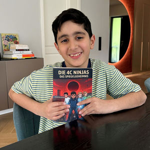 Malik Ekinci mit seinem Buch in der Hand am Esstisch.