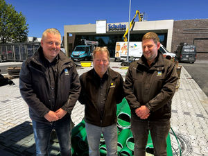 Fotomontage dreier Herren vor einer Supermarktbaustelle.