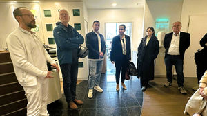 Zwei Damen und vier Herren stehen im Eingangsbereich einer Arztpraxis.