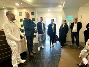 Zwei Damen und vier Herren stehen im Eingangsbereich einer Arztpraxis.