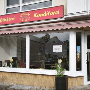 Geschlossene Filiale einer Bäckerei mit rotem Firmenschild.