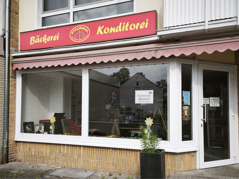 Geschlossene Filiale einer Bäckerei mit rotem Firmenschild.
