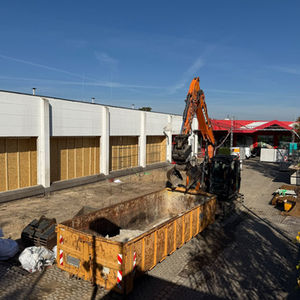 Bagger und Container vor der Baustelle am neuen Rewe-Supermarkt in Celle.