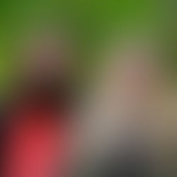 Zwei junge Schülerinnen draußen vor einem grün belaubtem Hintergrund.