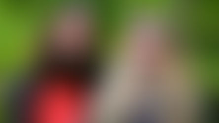 Zwei junge Schülerinnen draußen vor einem grün belaubtem Hintergrund.