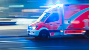 Rettungswagen im Einsatz vor verschwommenem Hintergrund.