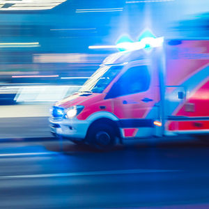 Rettungswagen im Einsatz vor verschwommenem Hintergrund.
