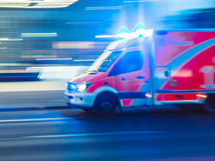 Rettungswagen im Einsatz vor verschwommenem Hintergrund.