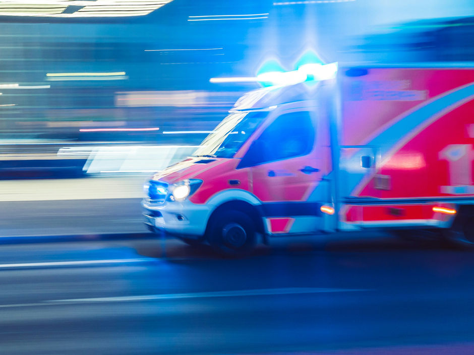 Rettungswagen im Einsatz vor verschwommenem Hintergrund.