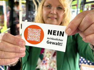 Evelyn Hollmann mit einem Aufkleber in der Hand.