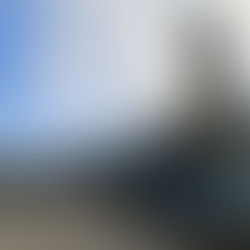 Eingangsbereich der IGS Celle mit Schornstein vor blauem Himmel mit einzelnen Wolken.