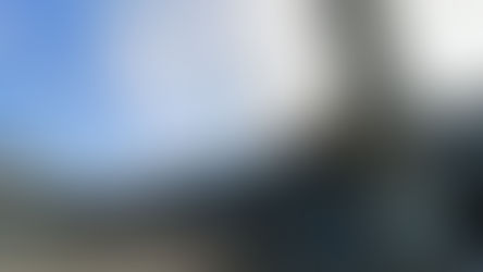 Eingangsbereich der IGS Celle mit Schornstein vor blauem Himmel mit einzelnen Wolken.