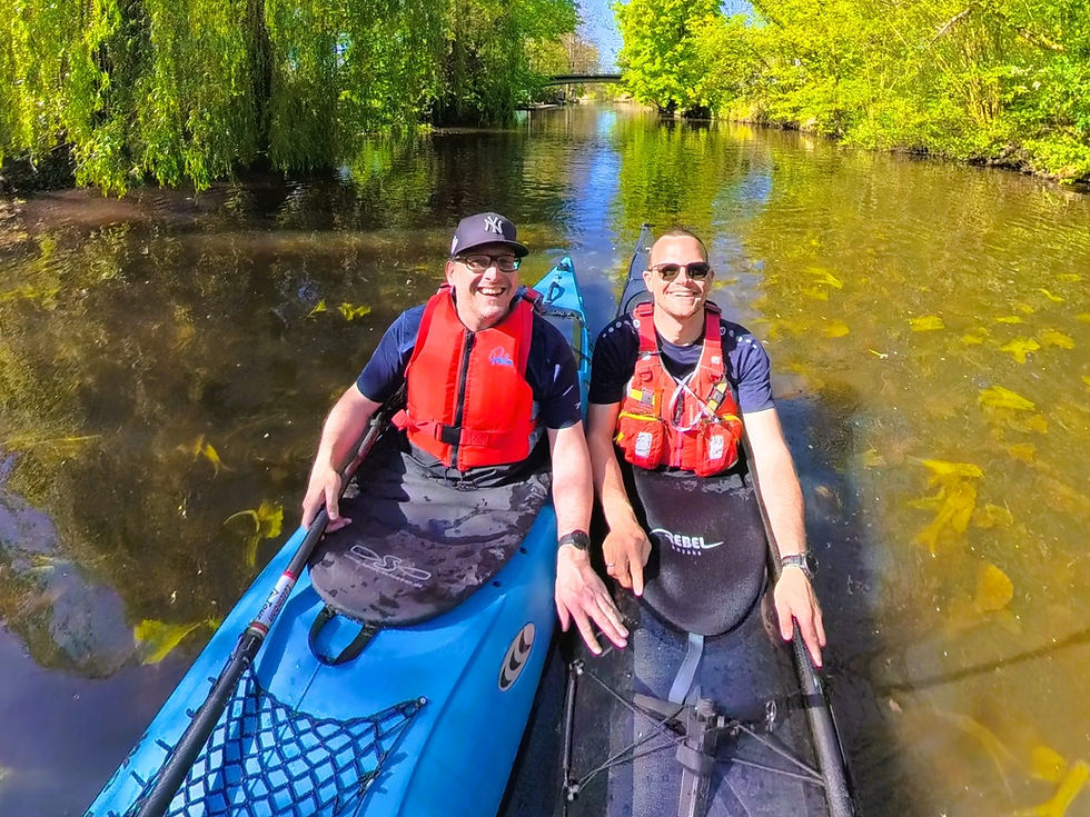 Zwei Männer in jeweils einem Kajak auf dem Wasser.