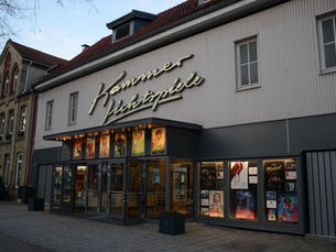Vorderseite der Celler Kammerlichtspiele mit Kinoplakaten.
