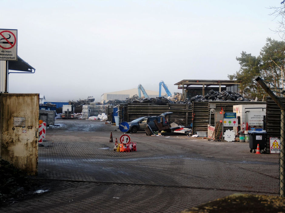 Abfallentsorgungsanlage mit Kränen und Reifenhaufen.