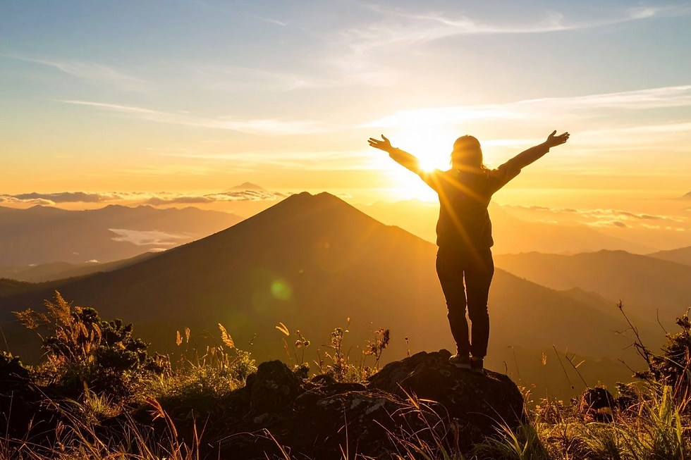 Woman on top of the hill admiring sunset