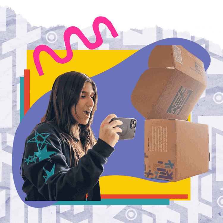 A young person in a patterned sweatshirt films on her phone while looking at stacked LitKit boxes, with a bright background