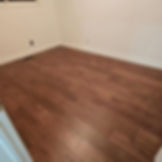 Finished reddish-brown hardwood flooring installation in a residential room