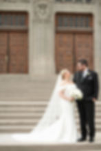 Bride holding bouquet of flowers looking at groom