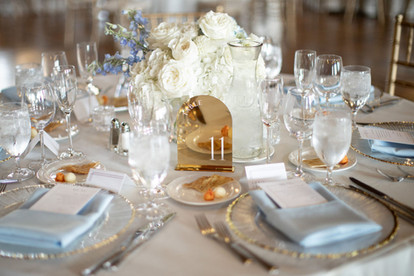 close up of guest table number with blue napkins and gold accents