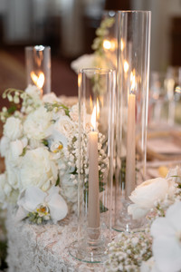 detail shot of candles on wedding sweetheart table with white florals around it