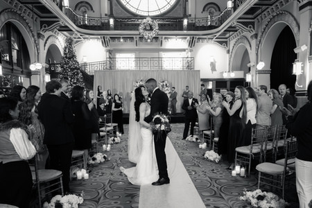 bride and groom kissing midway down the aisle post wedding ceremony