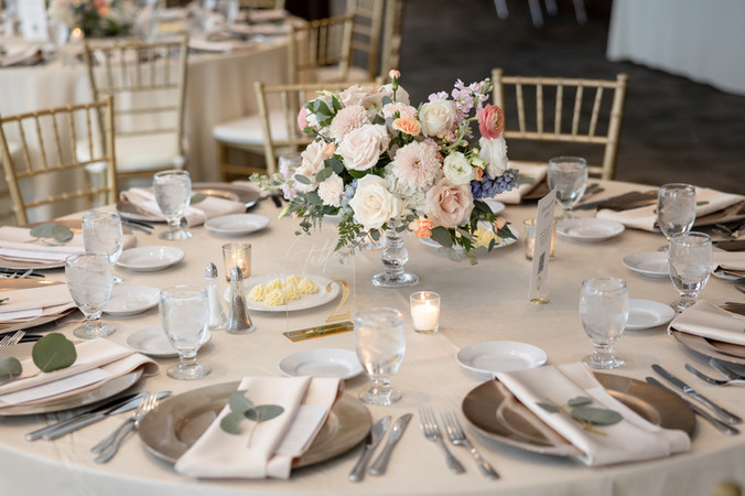 close up shot of guest table with place setting and florals in the middle