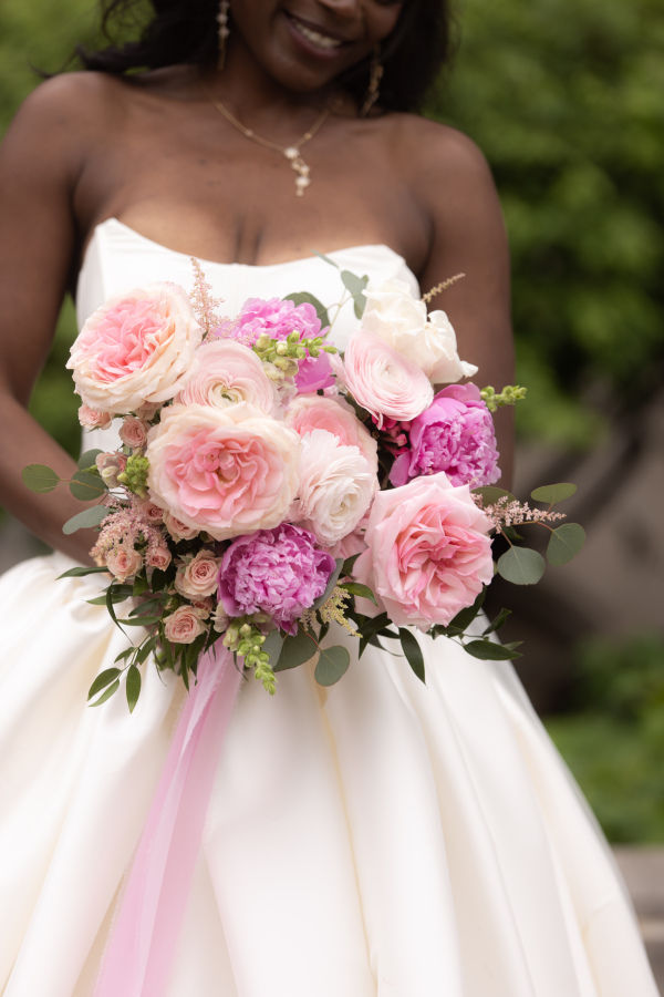 bride looking at pink bouquet