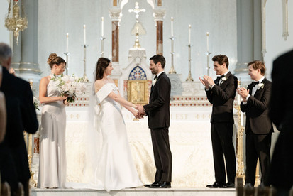 bride and groom holding hands in church during wedding