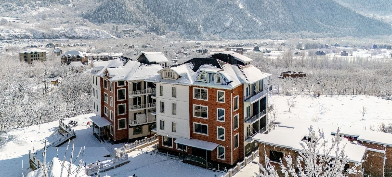 Snow View Hotel in Pahalgam During Winter – aerial exterior with valley backdrop