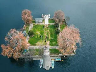 Tour operator in Kashmir arranging aerial view visit to Dal Lake island Srinagar with Shikara boats and autumn chinar trees
