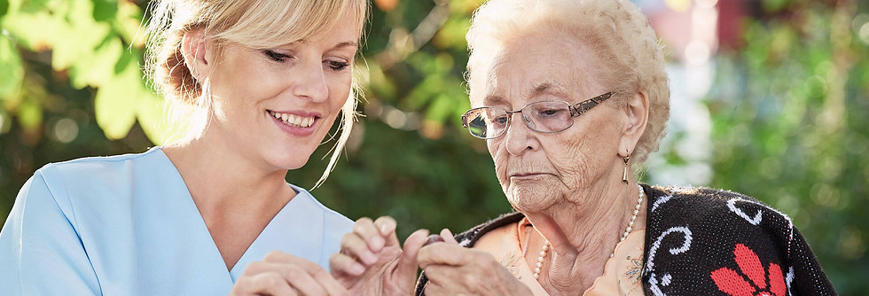 Pflegefachkraft mit Seniorin im Freien