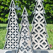 Intricate white wooden Christmas trees with custom geometric laser-cut patterns for holiday home decor.