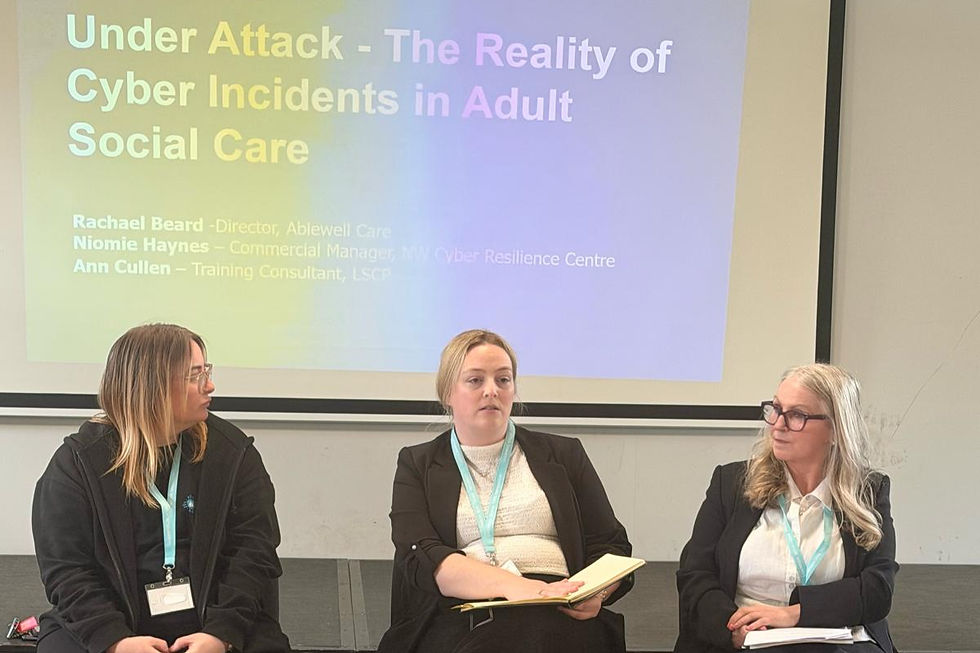 Three women seated in front of a projector screen with the title "Under Attack - The Reality of Cyber Incidents in Adult Social Care."