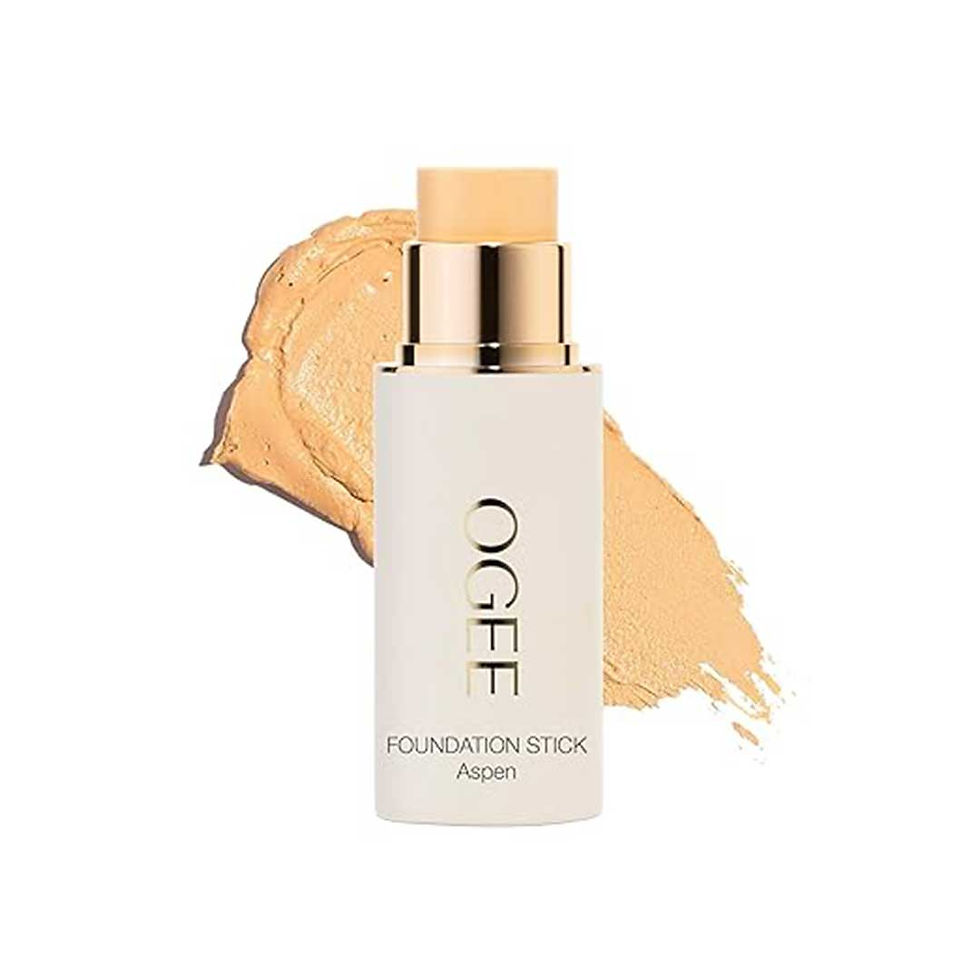 Ogee Foundation Stick Aspen, a foundation stick in a white tube with gold lettering, shown with a swipe of the foundation