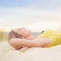 Caucasian woman laying on sand dune