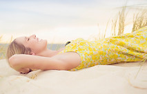 Caucasian woman laying on sand dune