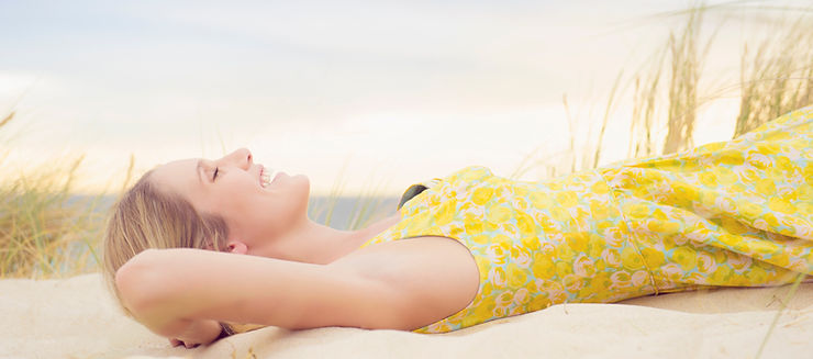 Woman Smiling And Laying On The Beach