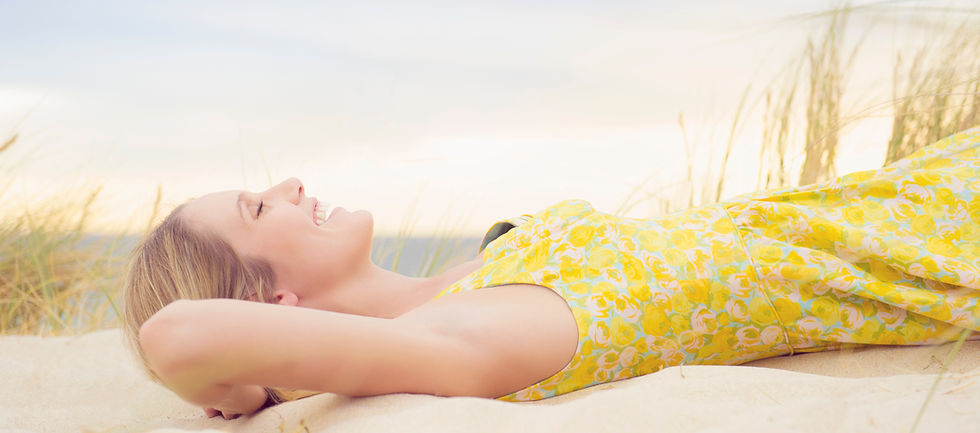 Woman Smiling And Laying On The Beach