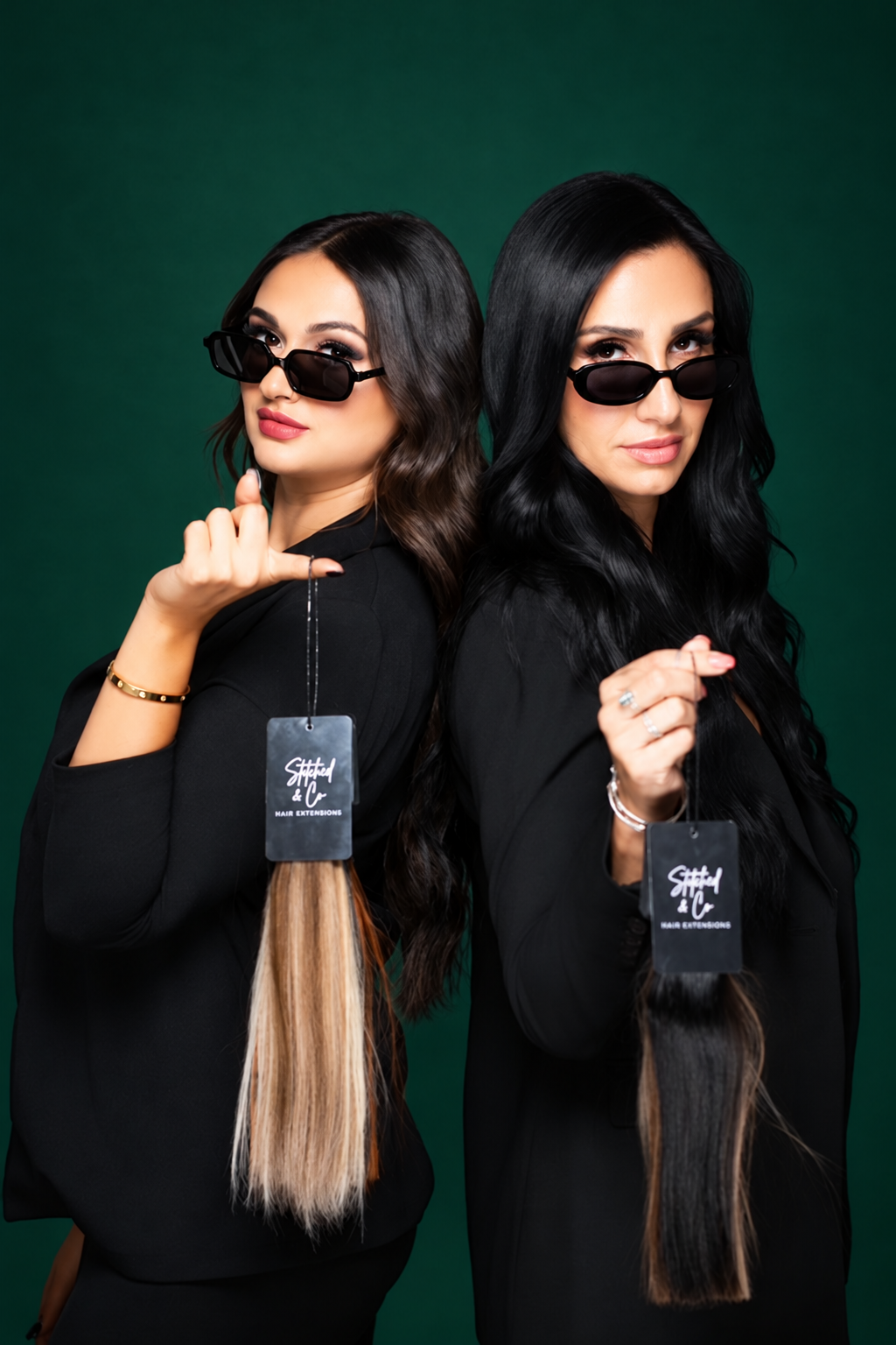 Bri and Gia with their Stitched & Co hair extensions against an emerald backdrop