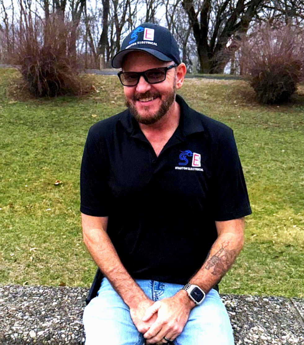 Patrick Stanton in black shirt, and cap outdoors