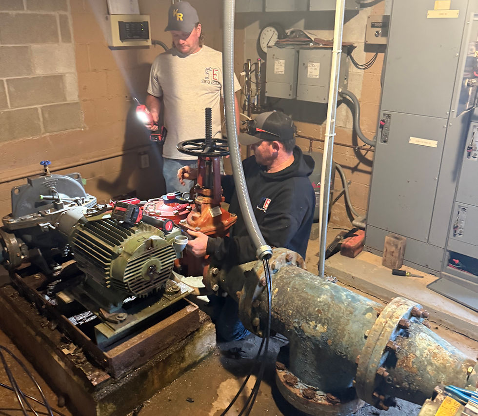 Two technicians working on industrial pumps and pipes