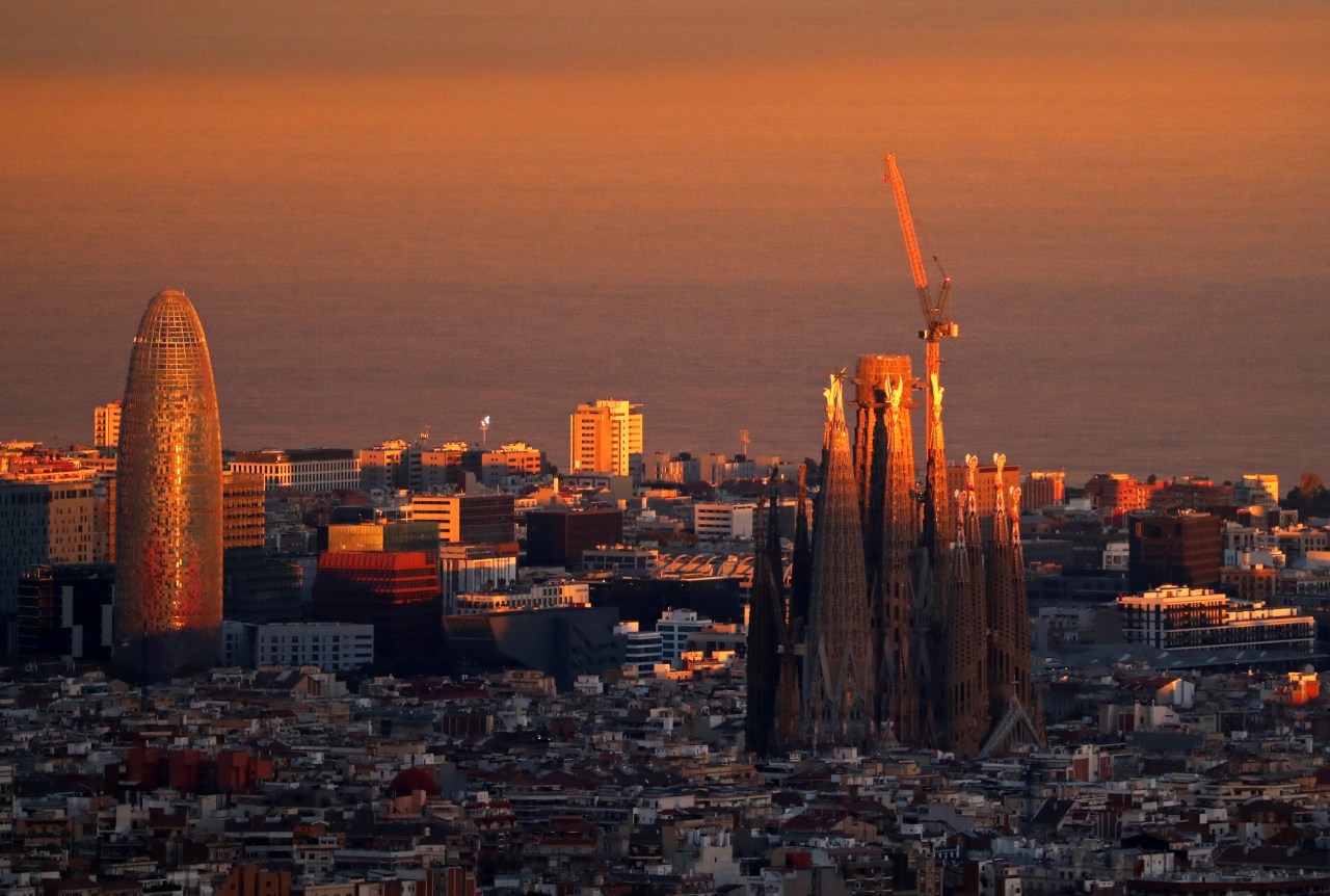 an aerial view from a distance of the Sagrada Familia in the evening light in Barcelona, Spain.