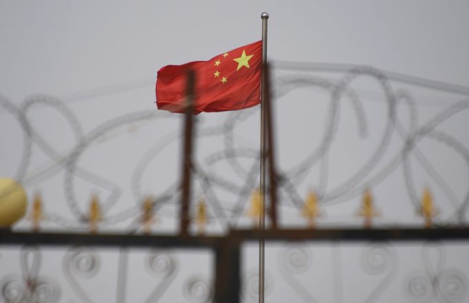 Chinese flag on pole behind razor wire
