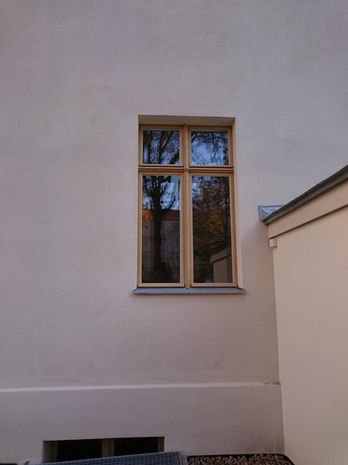 Holzfenster in heller Hauswand