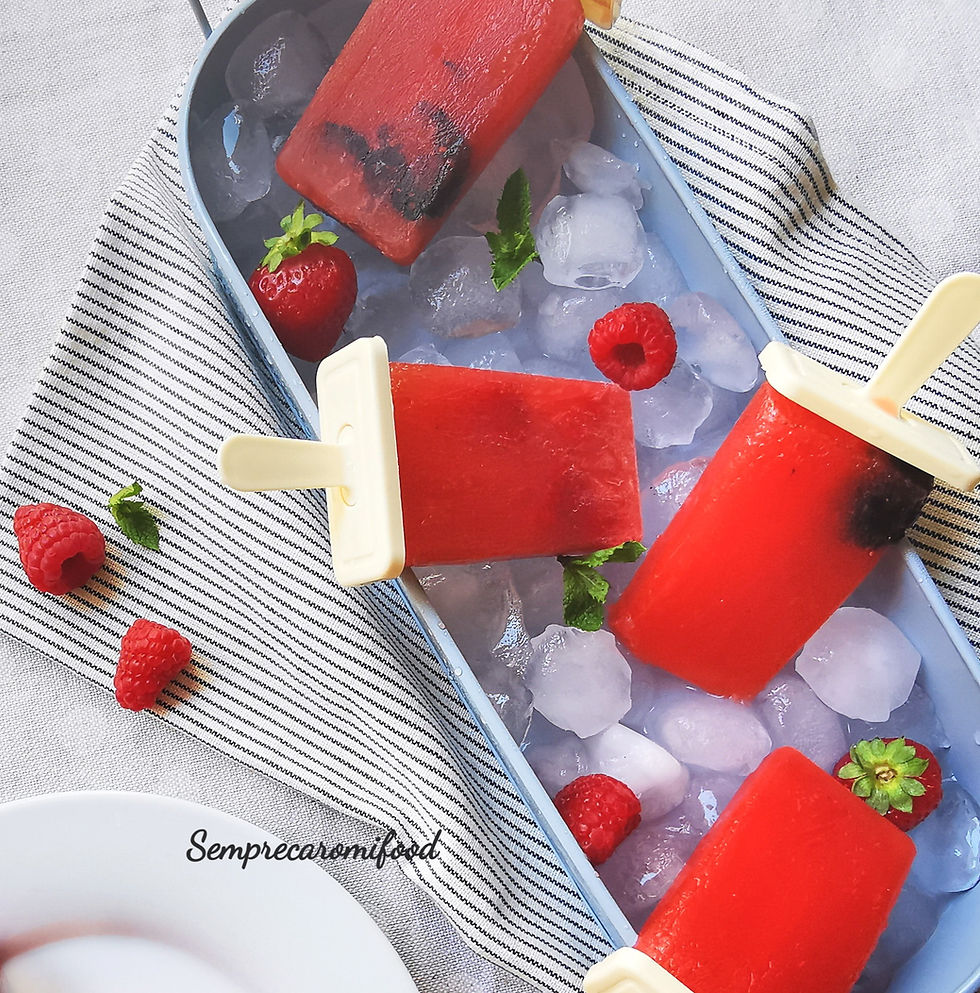 Ghiaccioli ai frutti rossi, fragole, lamponi e more su cubetti di ghiaccio in una vaschetta di metallo azzurro