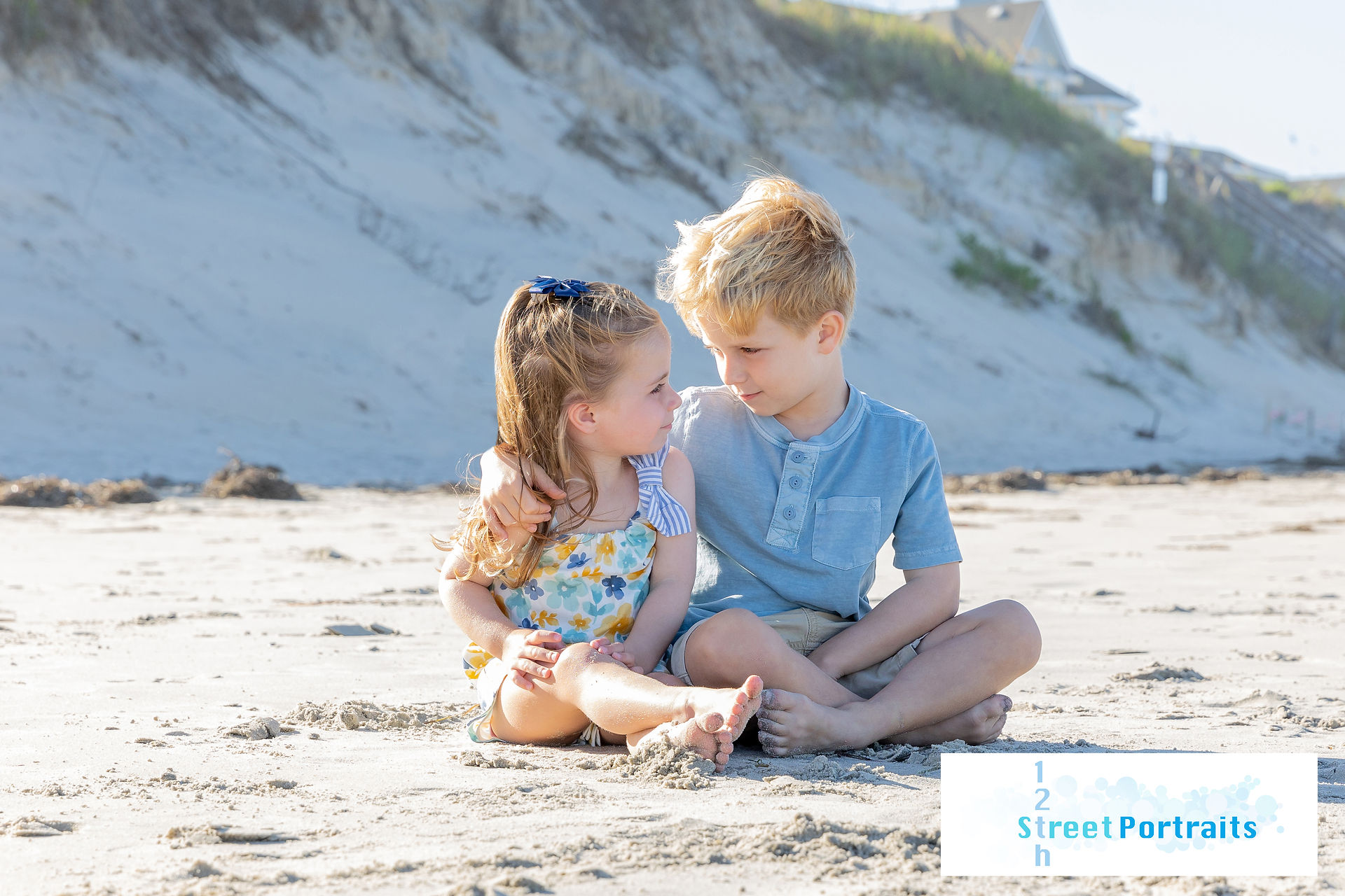 A brother and sister looking at eachother on the beach