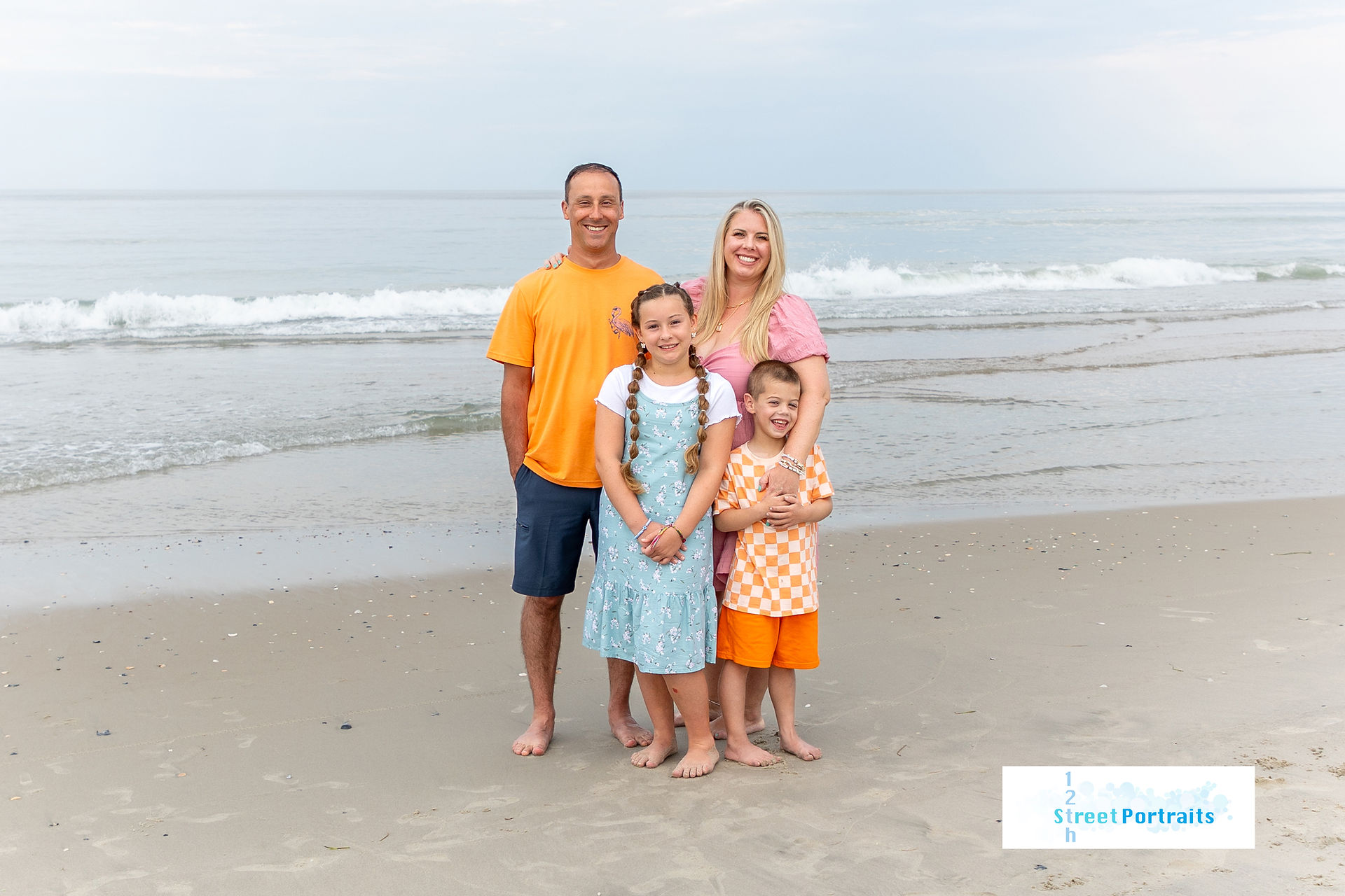 A family stands closely on the beach during a portrait session in Corolla, NC