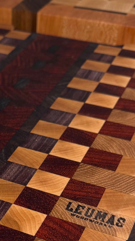 Padouk, maple, hickory, and Cherry end grain non culinary chopping block with Leumas Woodworks logo burned into the wood.