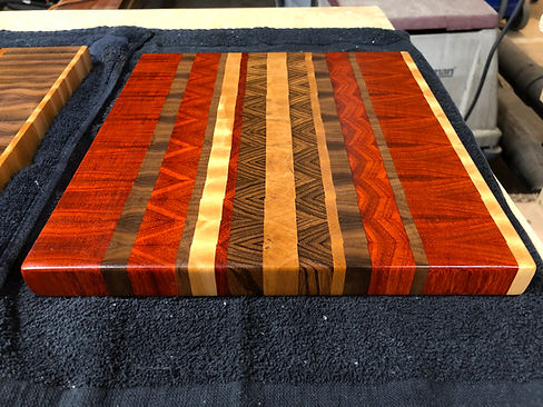 Deep red Padauk, walnut, cherry and maple cutting block